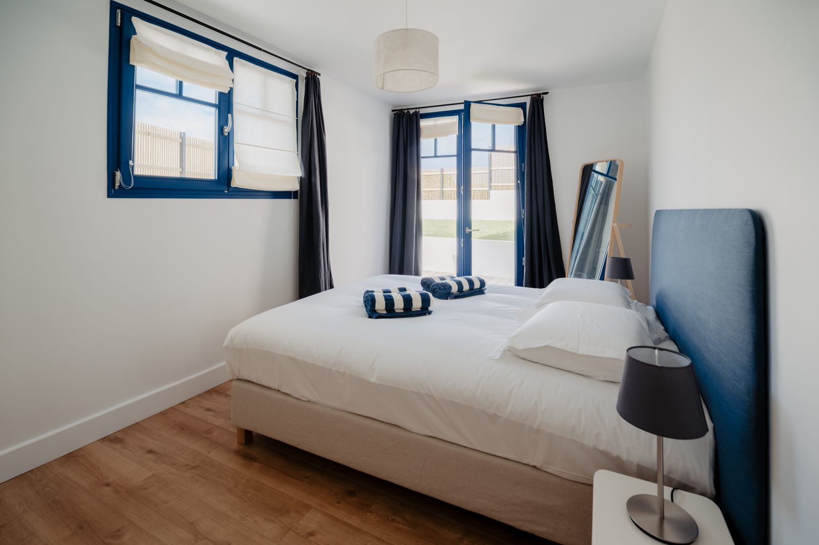 Garden-level bedroom with a large bed and windows onto the garden