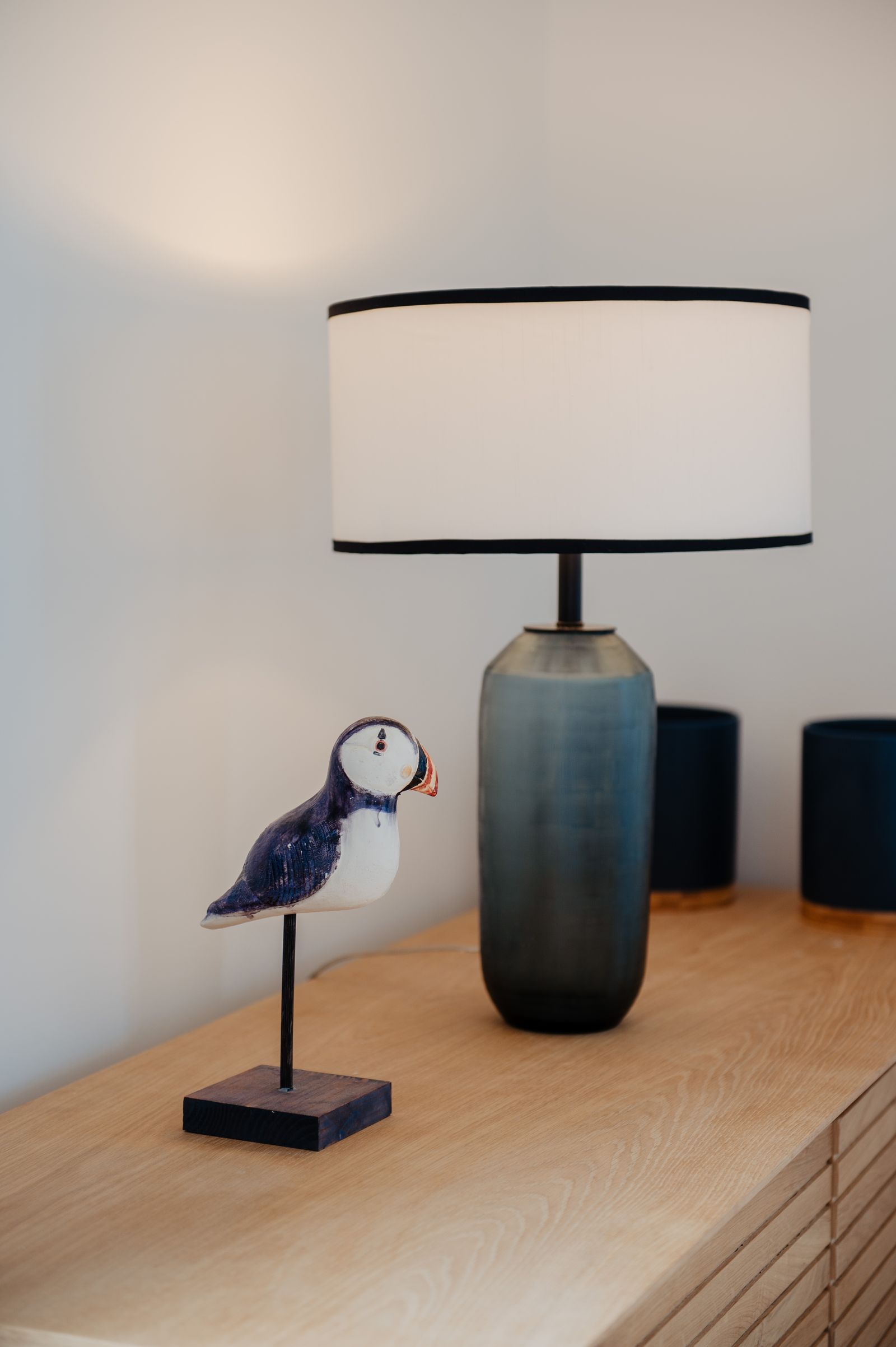 A wooden puffin on an oak chest of drawers