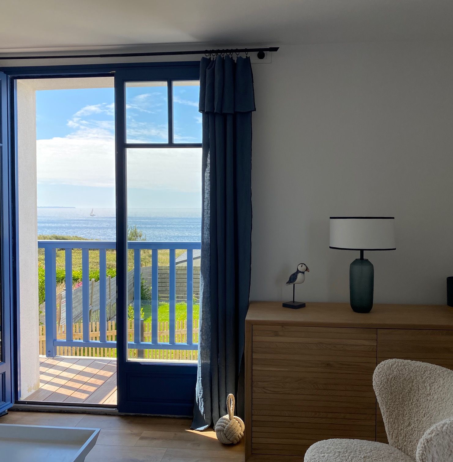The first-floor French window open onto the balcony and the sea