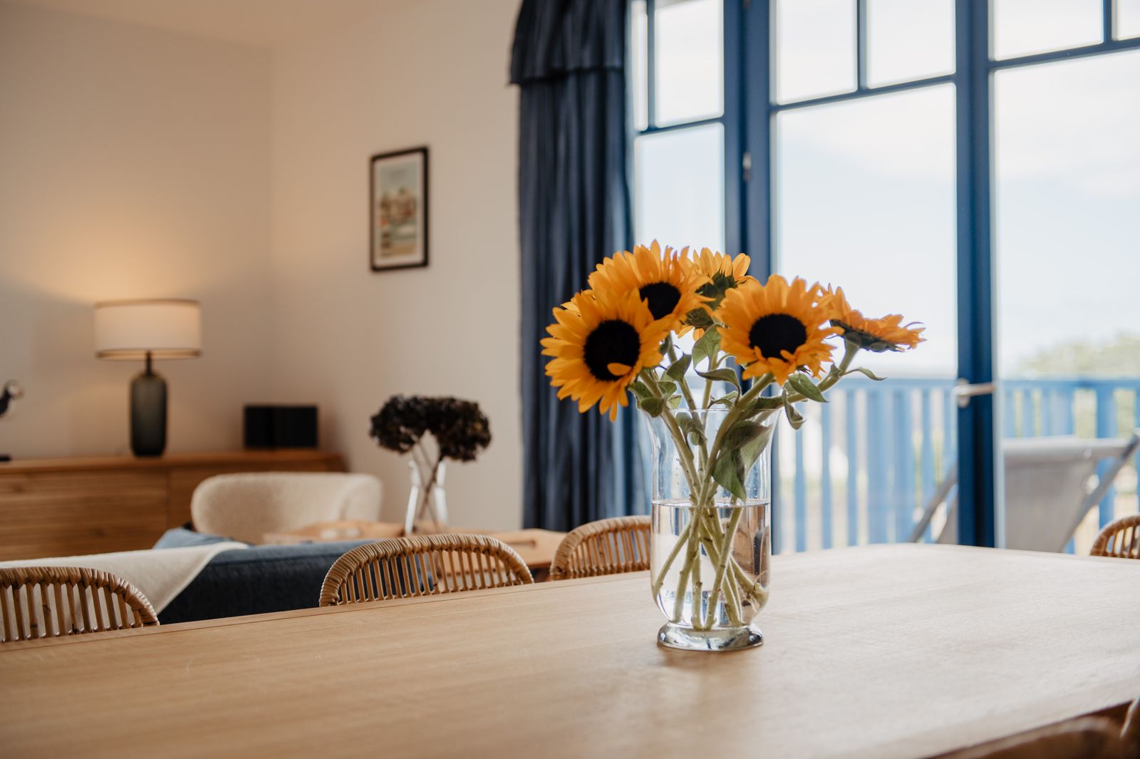 Sunflowers on the table, the sea behind the bay window